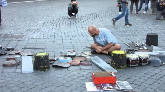 Un batteur de rue fait danser un gosse