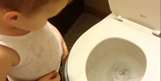 Un enfant fait un bisou à son poisson mort avant de le jeter dans les toilettes