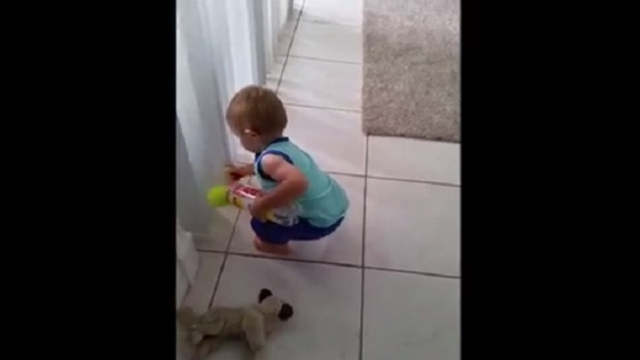 Un enfant tente désespérément de ranger des balles de tennis