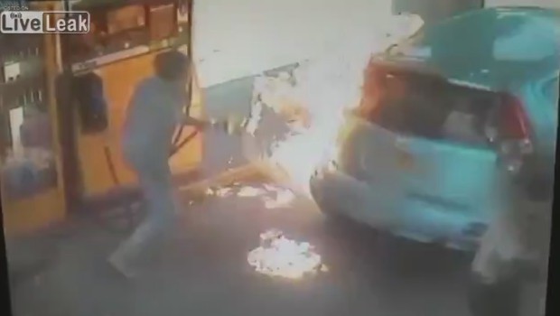 Une femme allume un briquet à une station-service