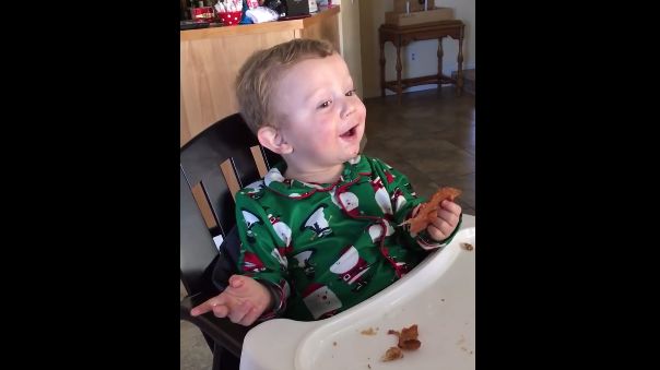 Un bébé mange son premier morceau de bacon