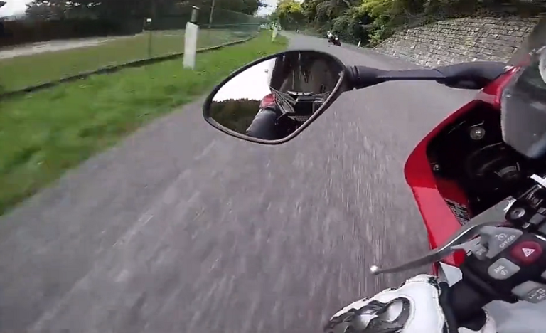 Deux motards font une course sur une route de montagne