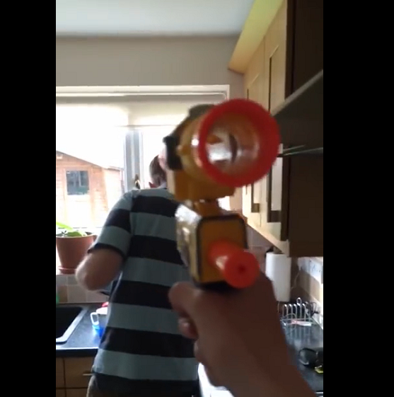 Un enfant tire avec un nerf tous les jours sur son père