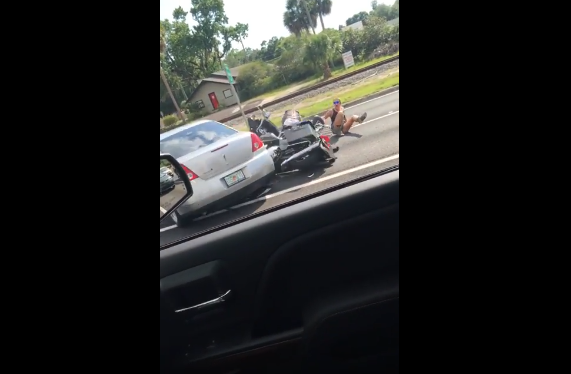Road Rage : une voiture grimpe sur une moto.