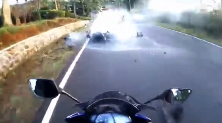 Un motard se couche pour éviter une voiture.