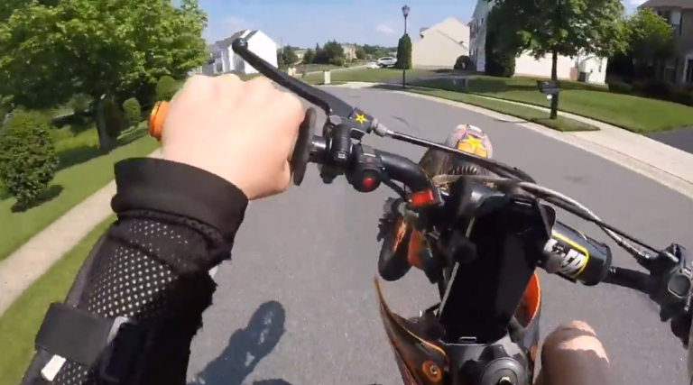 Un motard tente une roue arrière pour impressionner une jolie fille