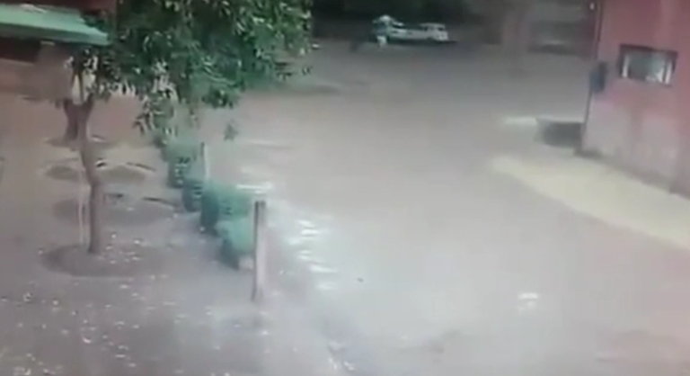 Une femme marche dans la rue avec un parapluie pendant un orage !