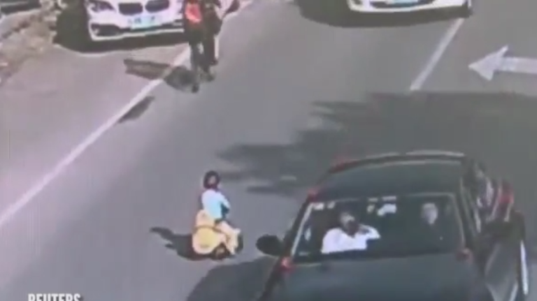 Un enfant en trotteur au milieu des voitures