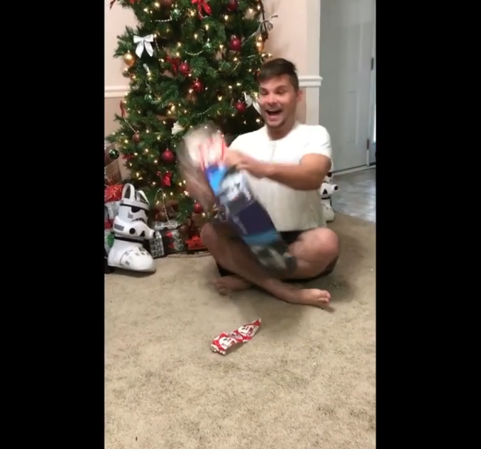 Un chat attaque un homme qui ouvre son cadeau de Noël