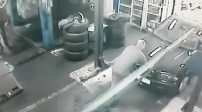 Un mécanicien tombe dans un trou en poussant une voiture