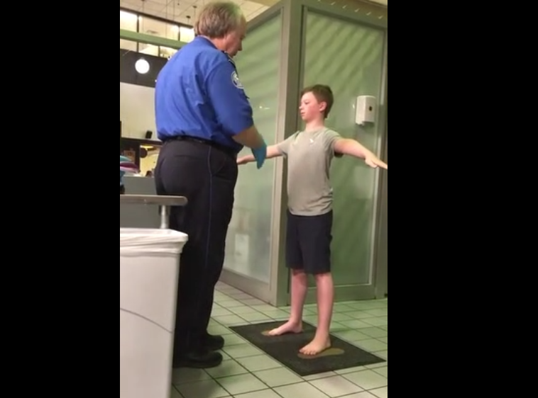 Un agent de sureté fait une fouille très près du corps à un enfant