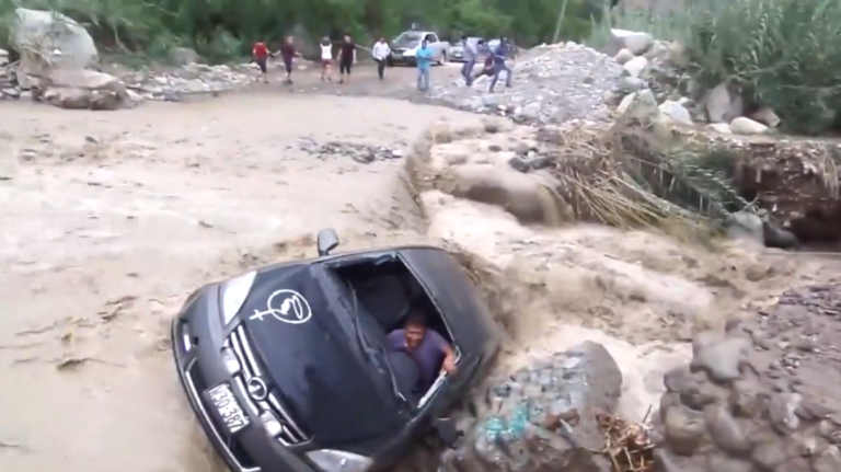 Un idiot traverse en voiture une rivière en crue