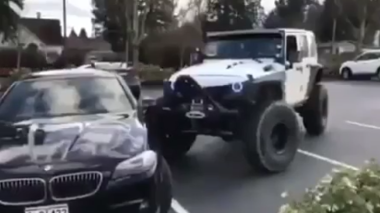 Une Jeep pousse une BMW mal garée