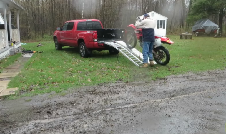 Chargement laborieux d&rsquo;une moto dans la benne d&rsquo;un pickup