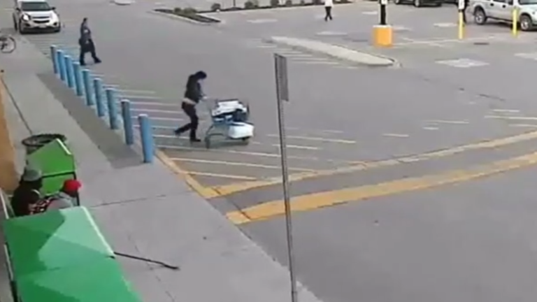 Une femme sort d’un supermarché en courant après avoir volé un caddie plein