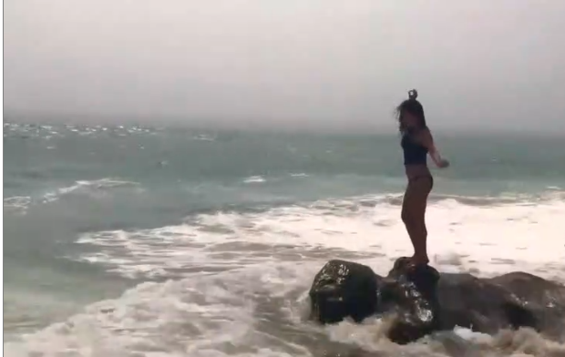 Une fille fait la belle au bord de la mer et finit par se prendre une vague !