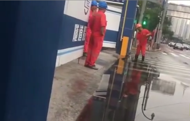 Un ouvrier surpris en train d’essayer de vider une flaque d’eau avec une pelle