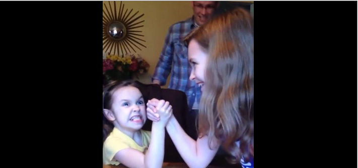 Une petite fille donne tout ce qu’elle a pour gagner à un bras de fer