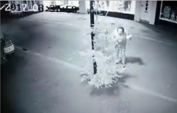 Un jeune frappe un sapin de Noël dans la rue devinez qui termine au sol