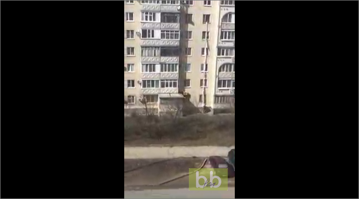 Une femme au 5eme étage noue des draps pour récupérer un colis