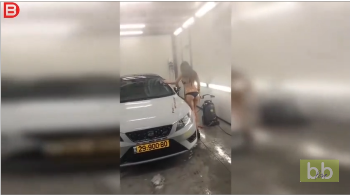 Une fille sexy en bikini et talons tombe en lavant une voiture…