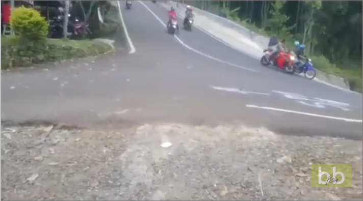Deux hommes en scooter font une sortie de route violente dans une descente en Indonésie