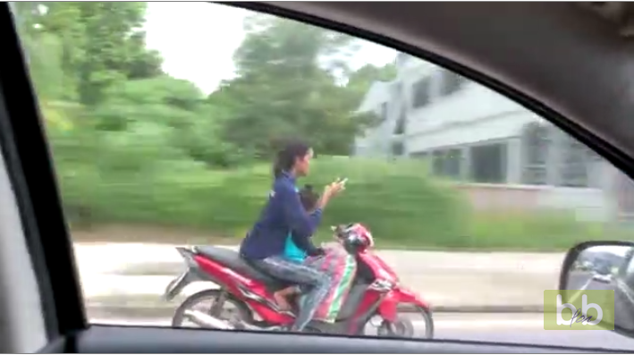 Une mère envoie des textos pendant qu’elle roule avec sa fille en scooter