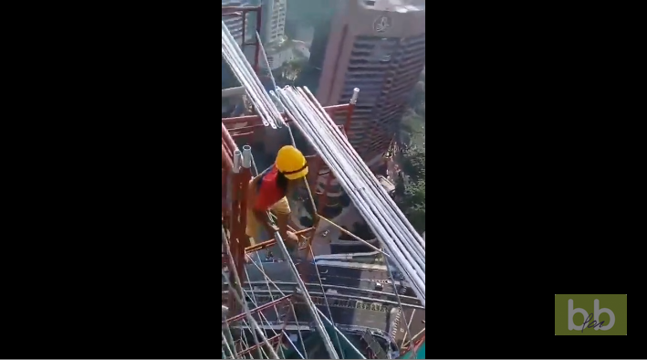 Des ouvriers montent un échafaudage au sommet d’un immeuble sans aucune sécurité