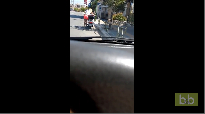 Une fille blonde croit qu’un scooter se démarre en appuyant sur la béquille