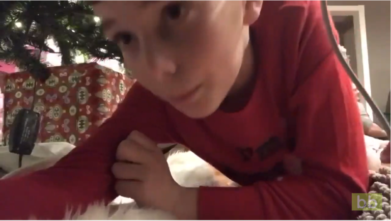 Un enfant place une caméra sous le sapin pour filmer le Père Noël