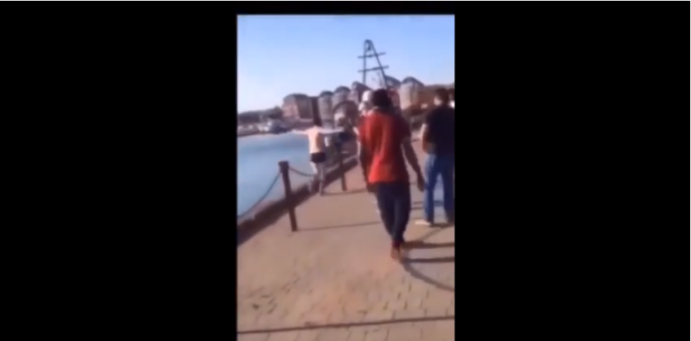 Un homme vraiment très heureux veut sauter dans l’eau d’un port