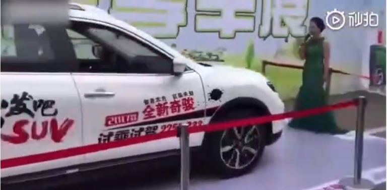 Une femme se met devant une voiture pour tester le freinage automatique d’une voiture