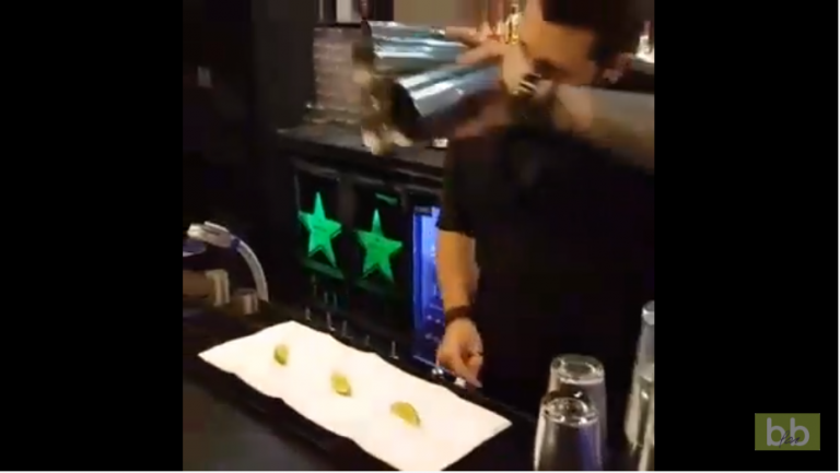 Un barman impressionne des clients en faisant un tour de magie avec des fruits