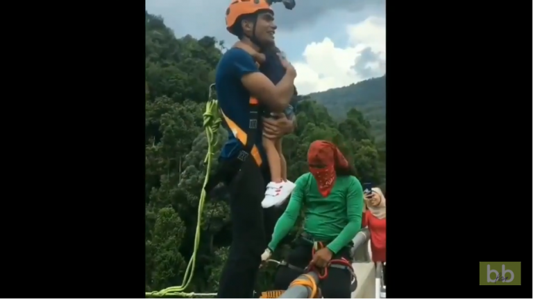 Un homme stupide fait un saut pendulaire avec sa fille dans ses bras